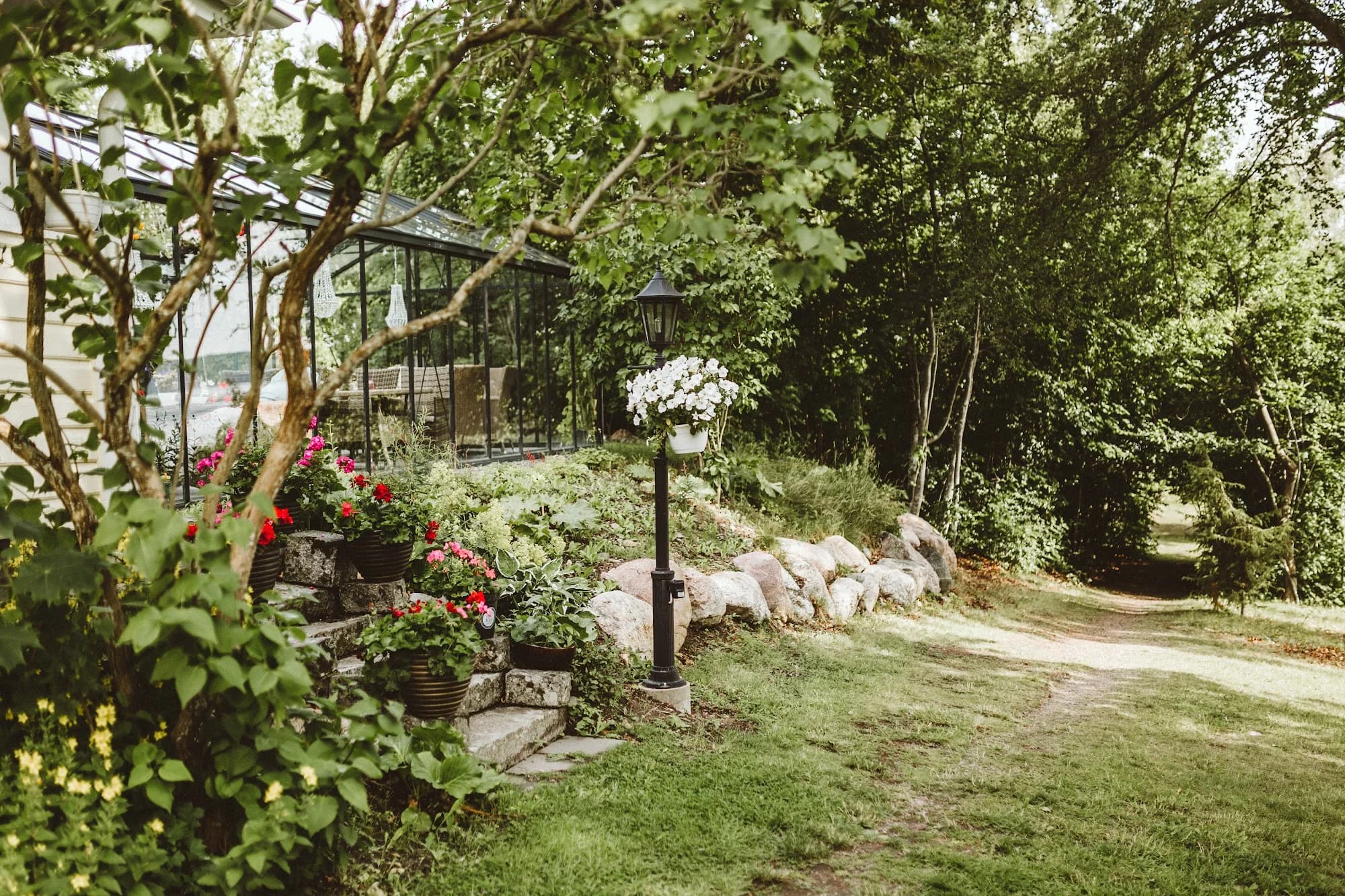 Flowering garden beds and the glasshouse beside the Main House