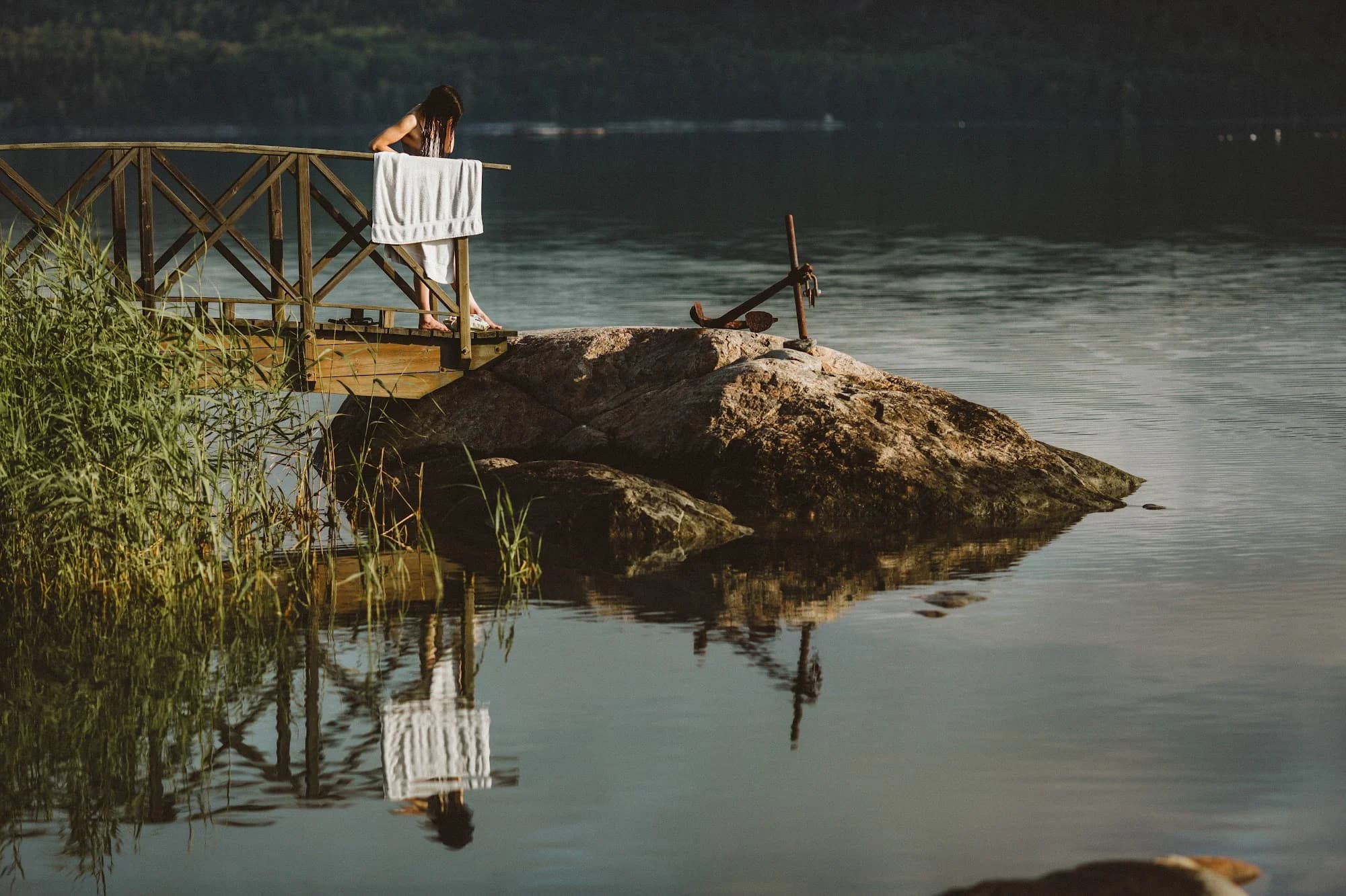 A jetty and rocks reflected in calm water