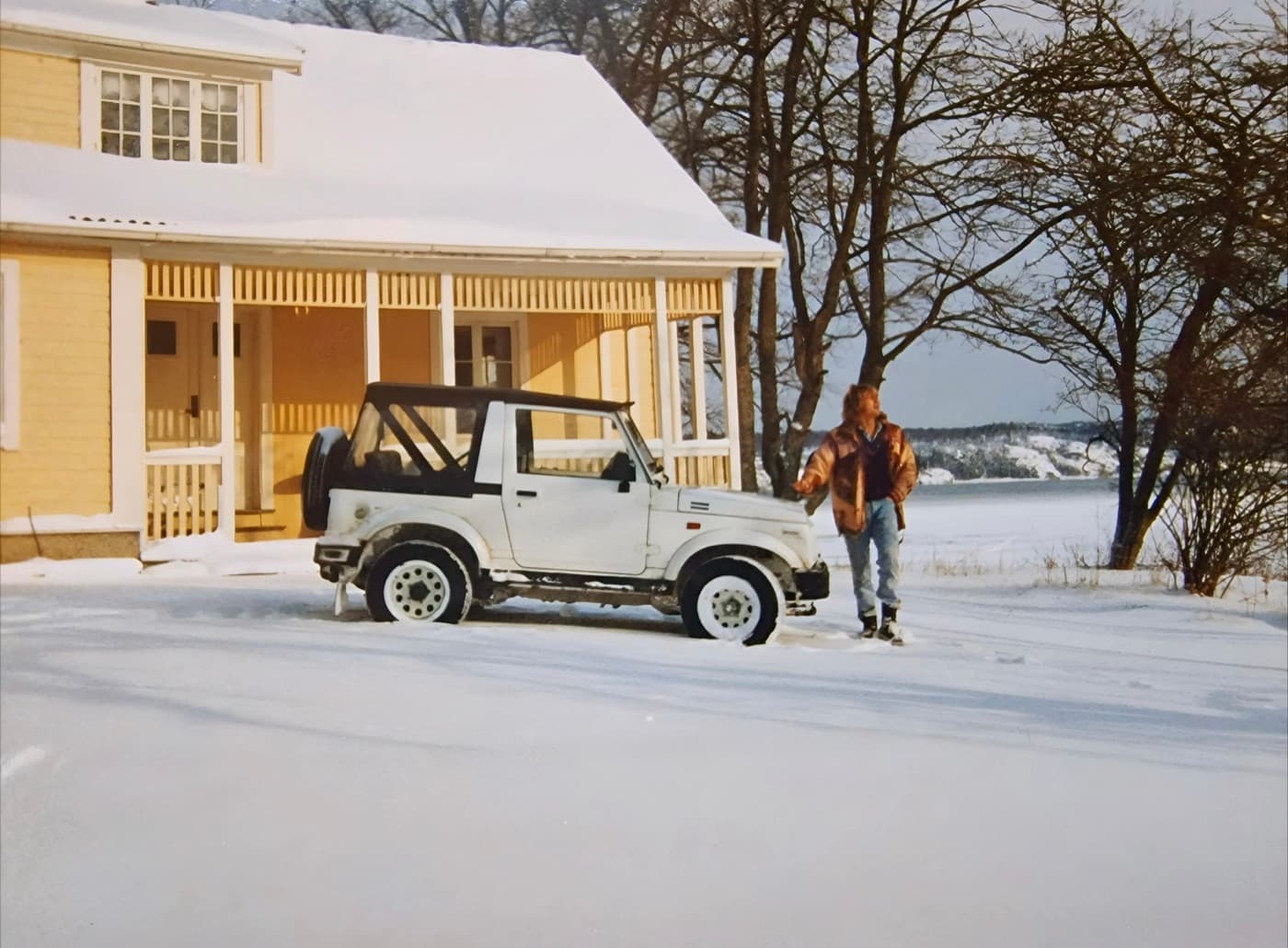A snowy winter day in front of the yellow main house