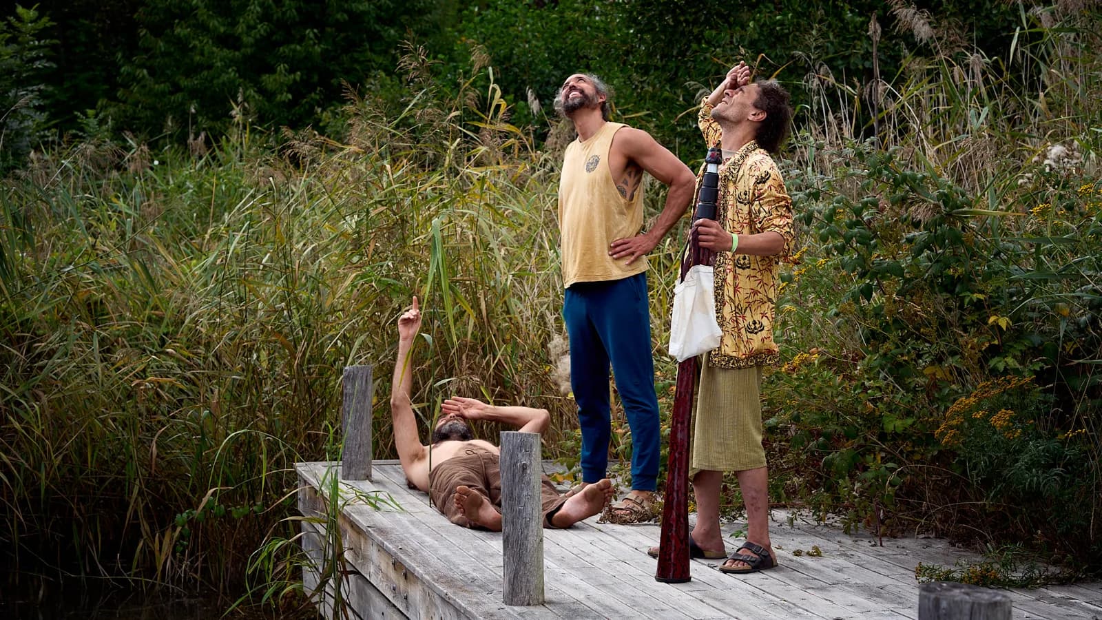 People making music together on a jetty among the reeds