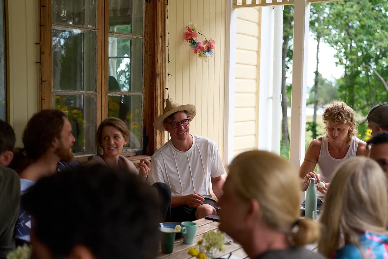 People sharing a meal and conversation on the veranda