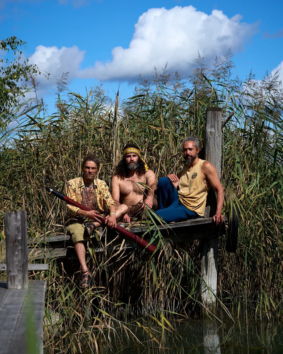 Three participants sitting together among tall reeds