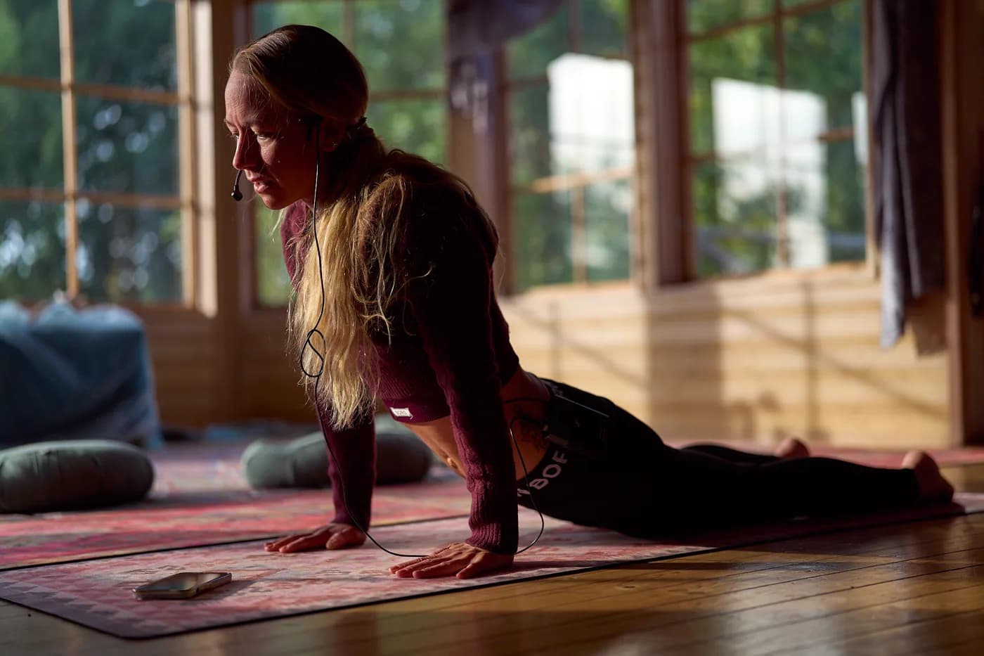A participant stretching on a mat beside a sunlit window