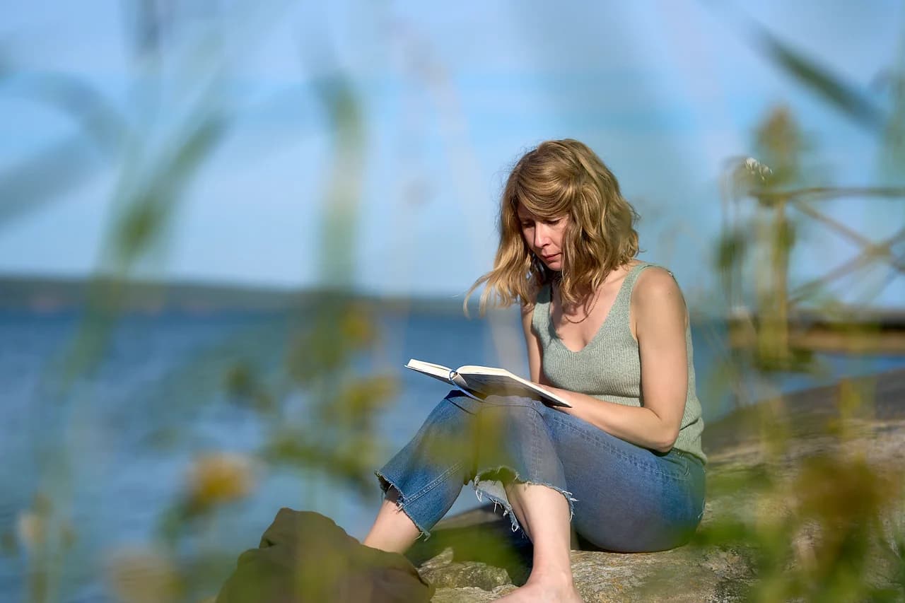 A participant reading on the rocks beside Bråviken